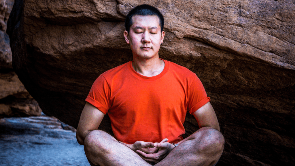 Meditative man by a rock