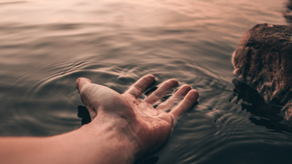 A man facing his healing palm up in water